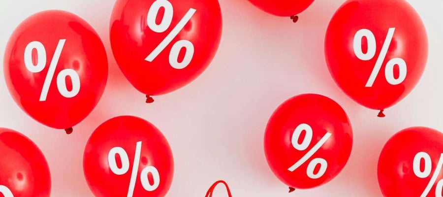 bag on podium surrounded by balloons that have a percentage mark on them.