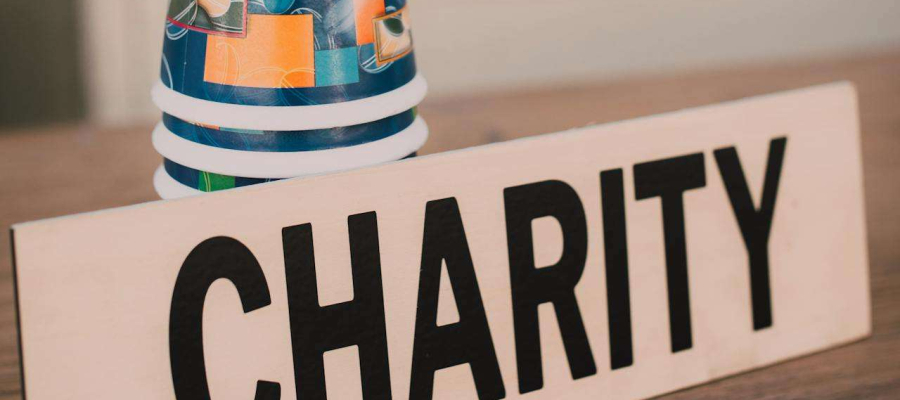 a table with cups and a charity sign post on it
