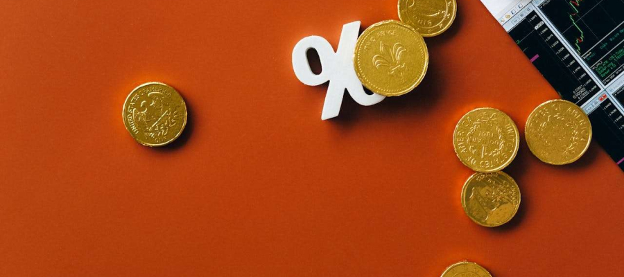 coins over a percentage sign and an investment graph