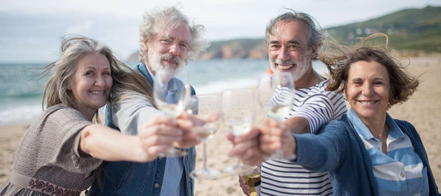 elderly people drinking wine by the sea