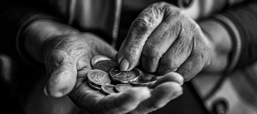 elderly person holding a hand full of coins