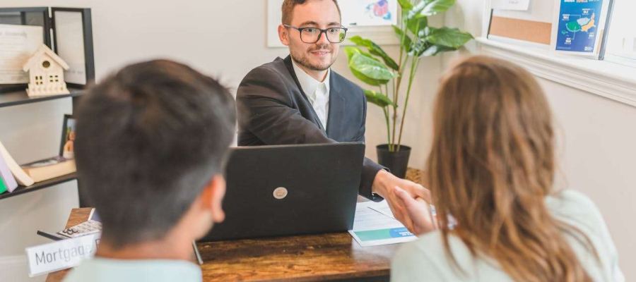 a man shaking the hand of a woman in a meeting