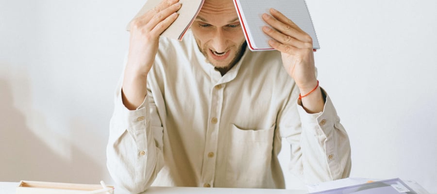 a man holding books and looking very stressed