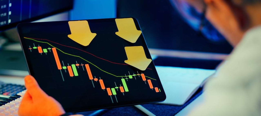 a person sitting with a tablet that is showing a market downturn