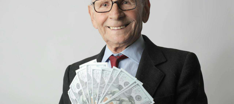 an older man holding a handful of notes
