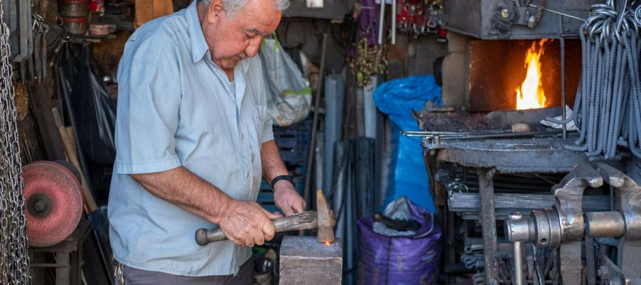 an older man still working. Blacksmithing work