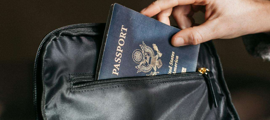 a person putting a passport into a black bag