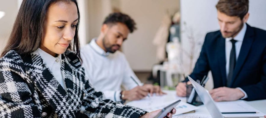 three people sitting in an office working.