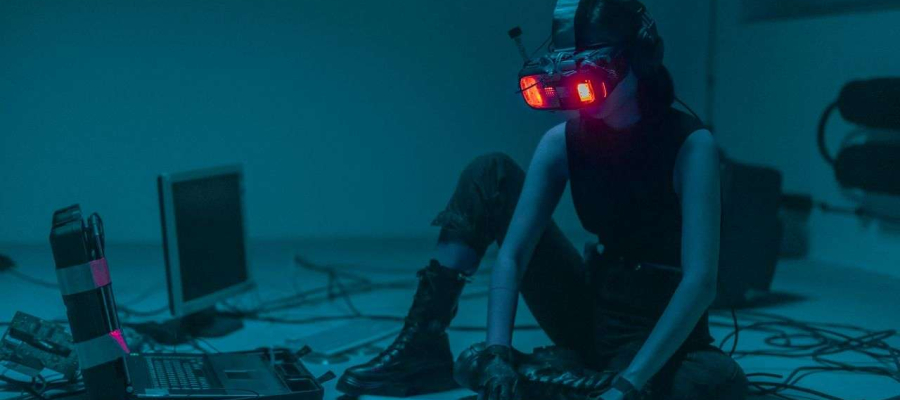 a person with a VR headset on surrounded by different laptops and computers