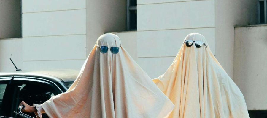 two people wear a ghost costume wearing sun glasses