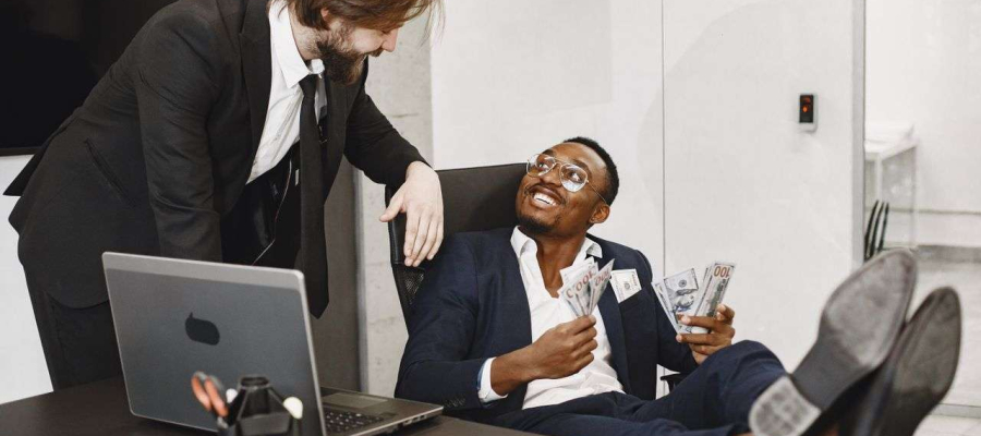 two people in an office. One person holding handful of money