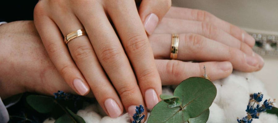 two people who have just got marriage showing rings and flowers