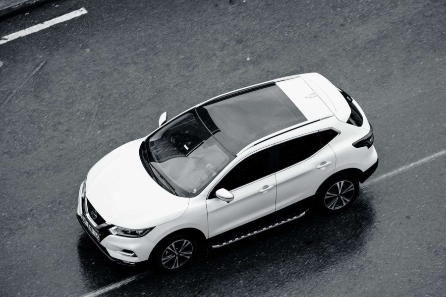 A White Car Driving On A Road