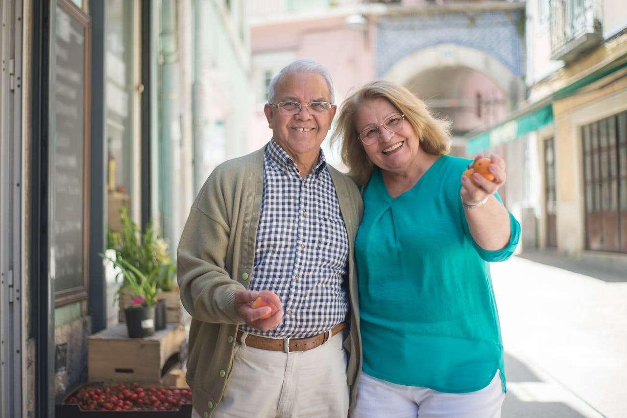 Elderly couple smiling while on a high street shopping.