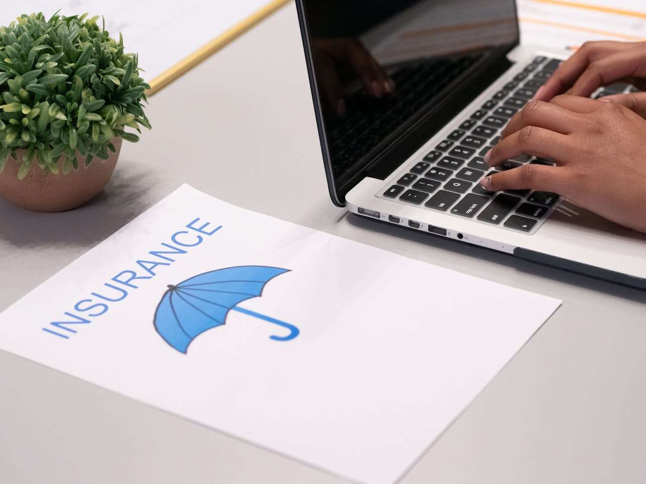 paper showing insurance next to a laptop