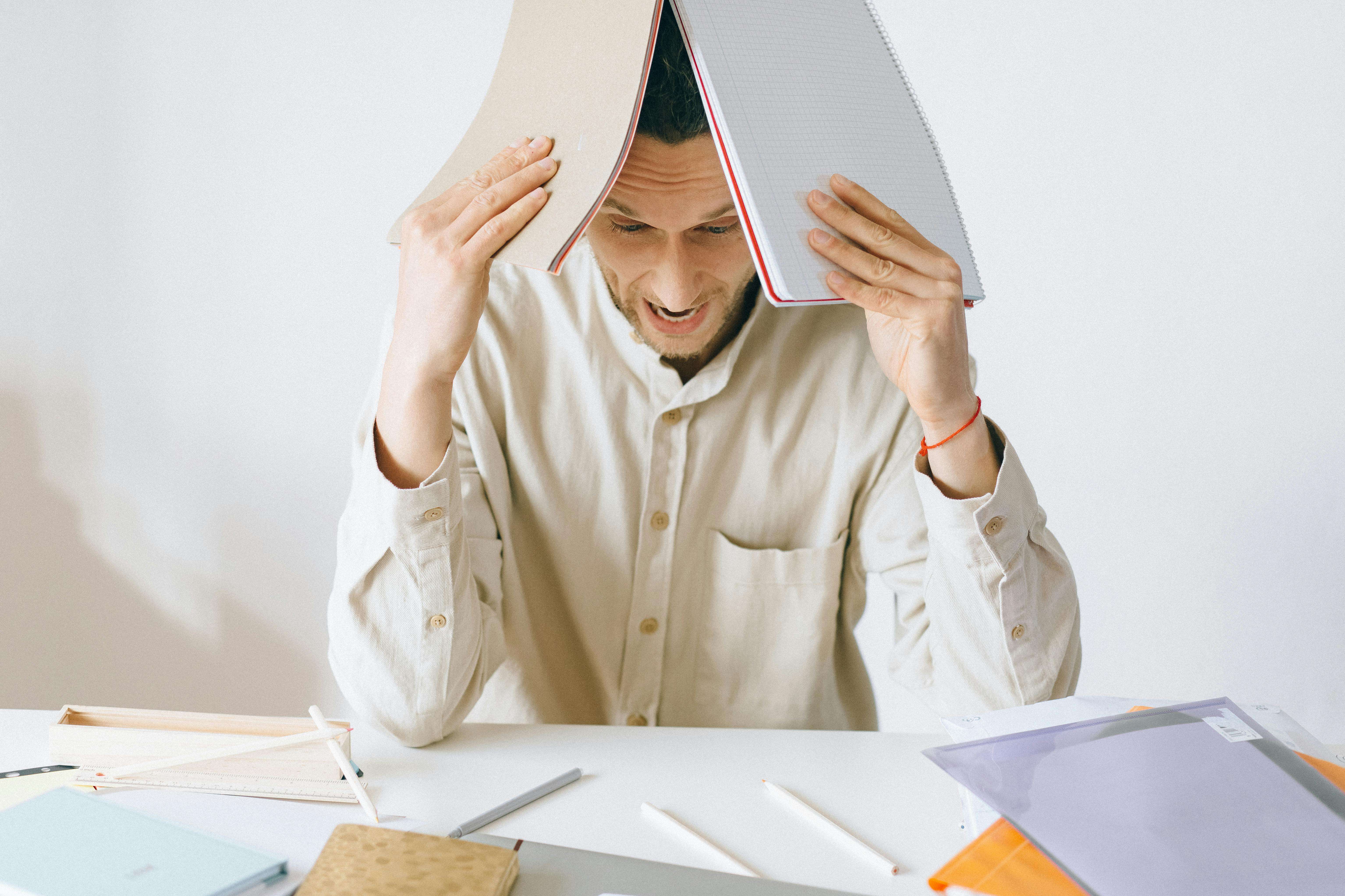 a man holding books and looking very stressed