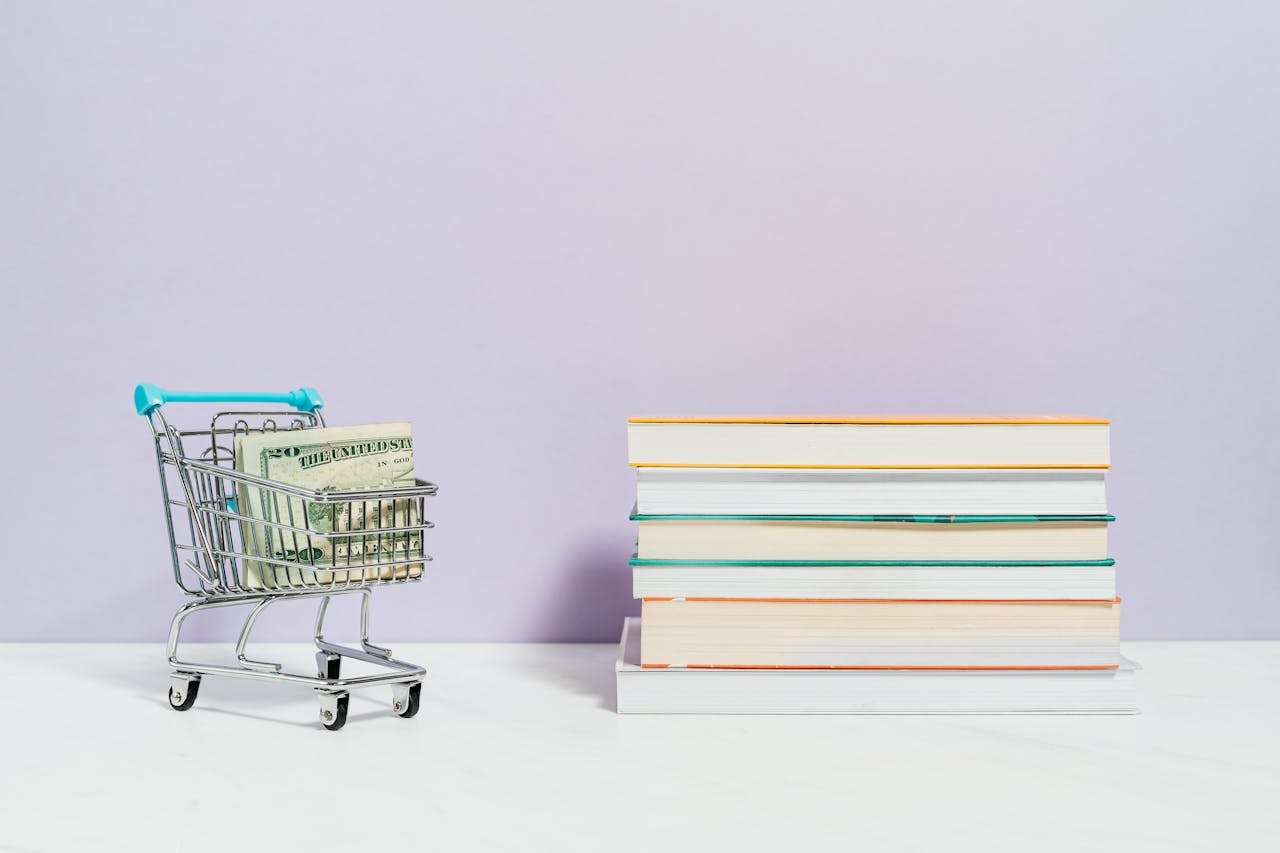 a trolly with money inside is next to a stack of books.