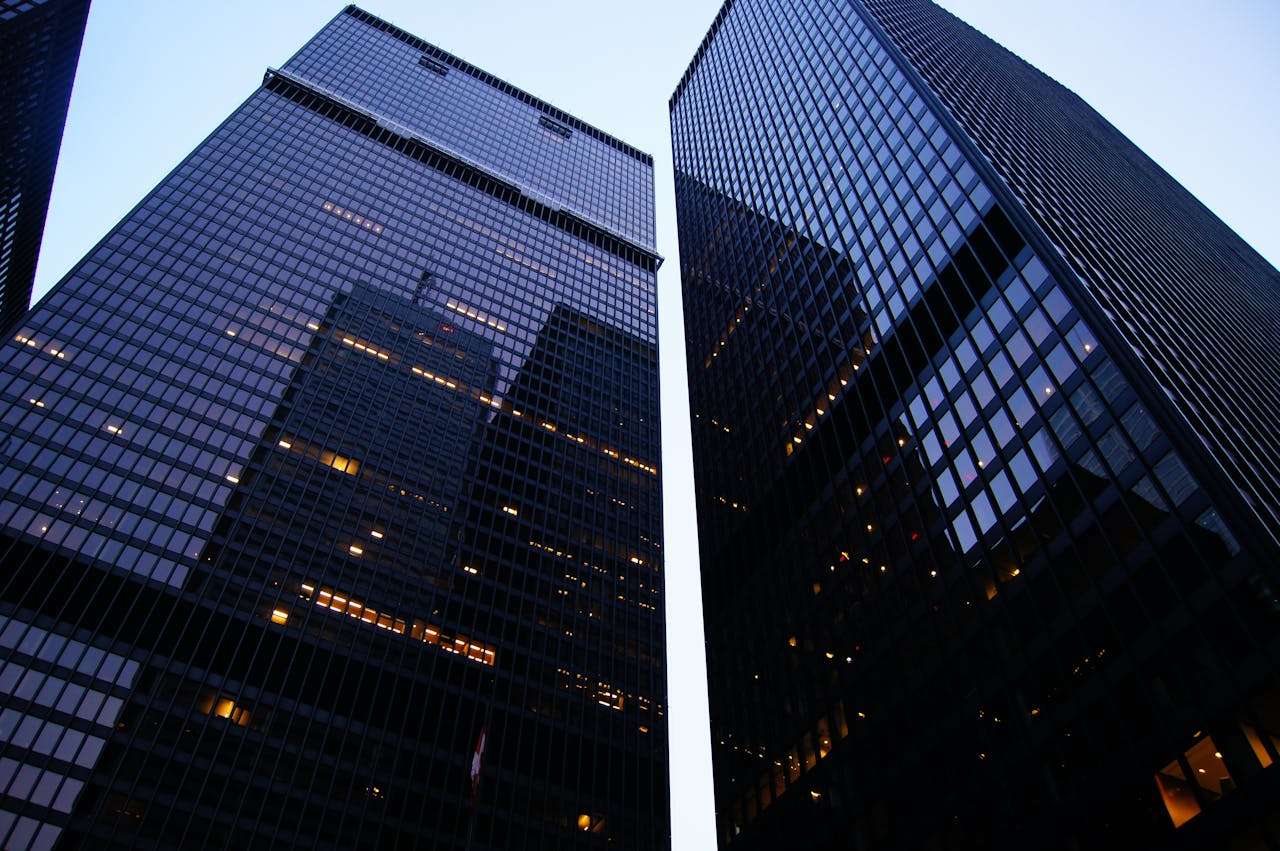 two large office buildings next to one another,