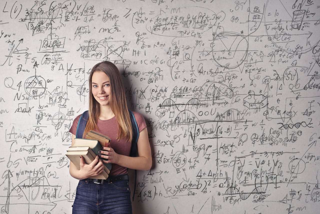 a student in front of a board of sums.