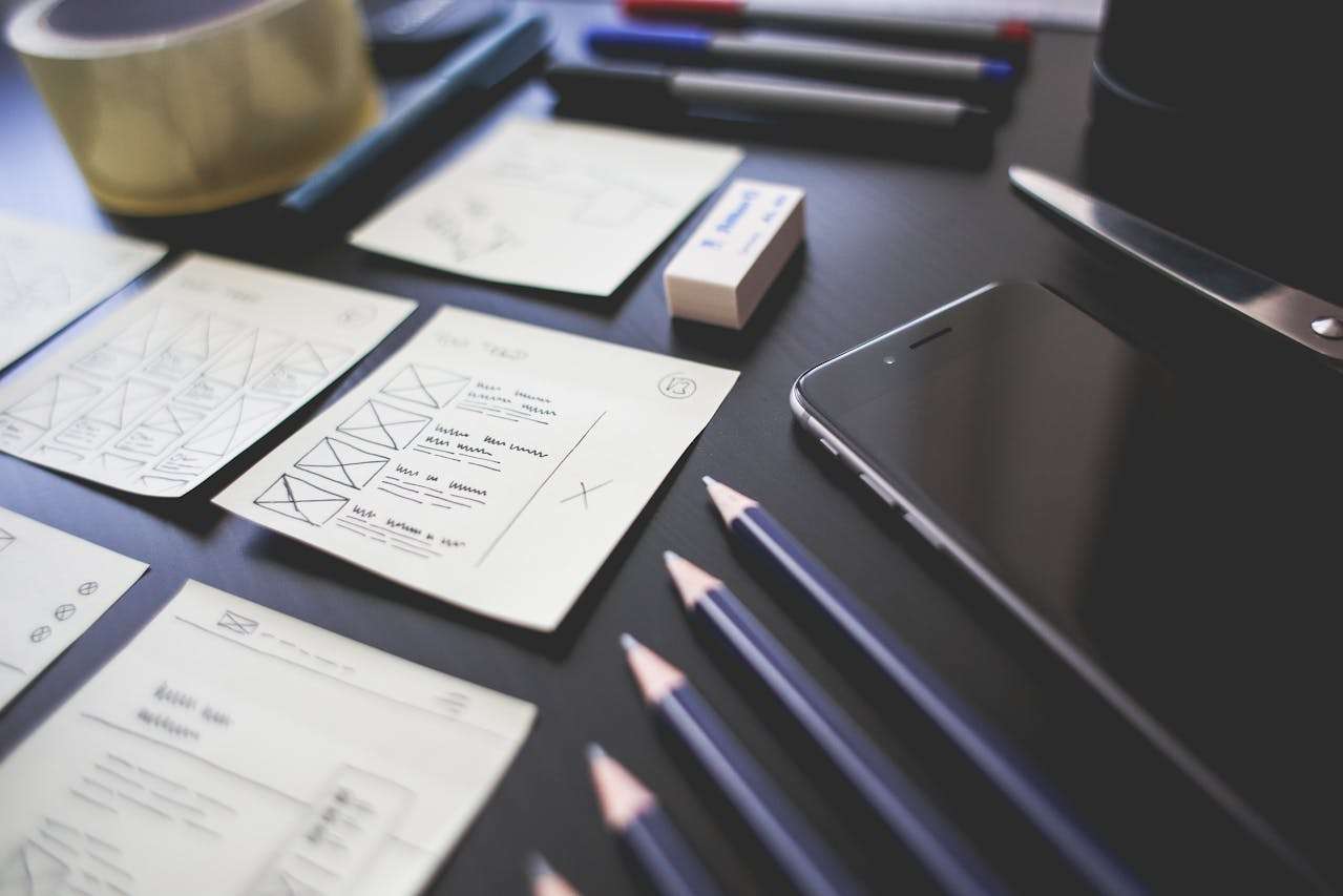 a desk with various notes, pencils and a phone