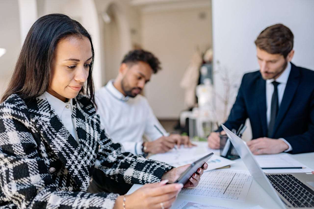 three people sitting in an office working.