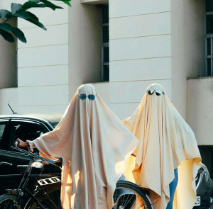 two people wear a ghost costume wearing sun glasses