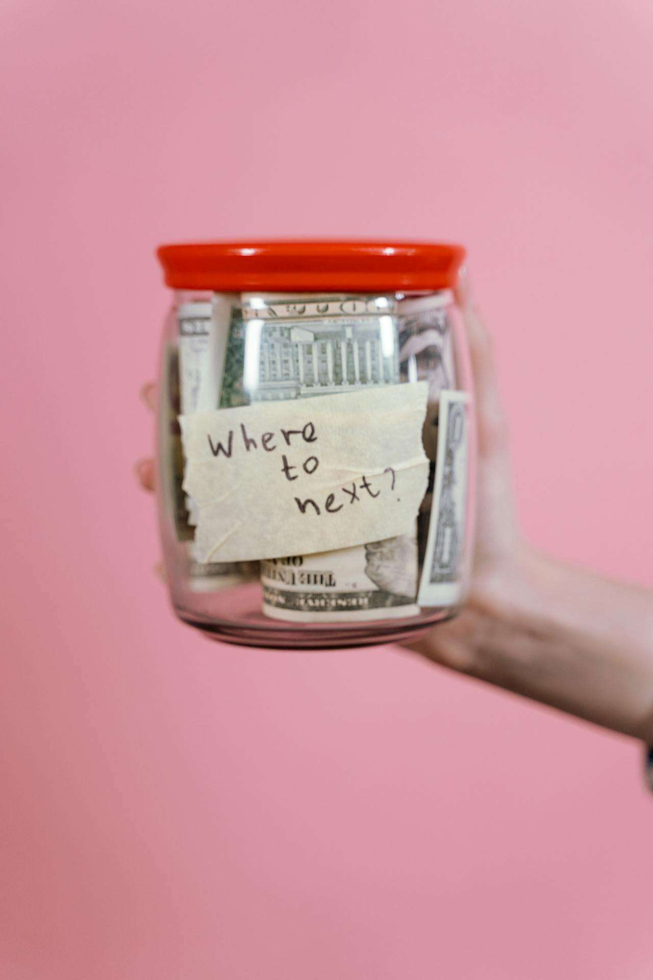a jar with money in it. The jar is full and has the text where to next on