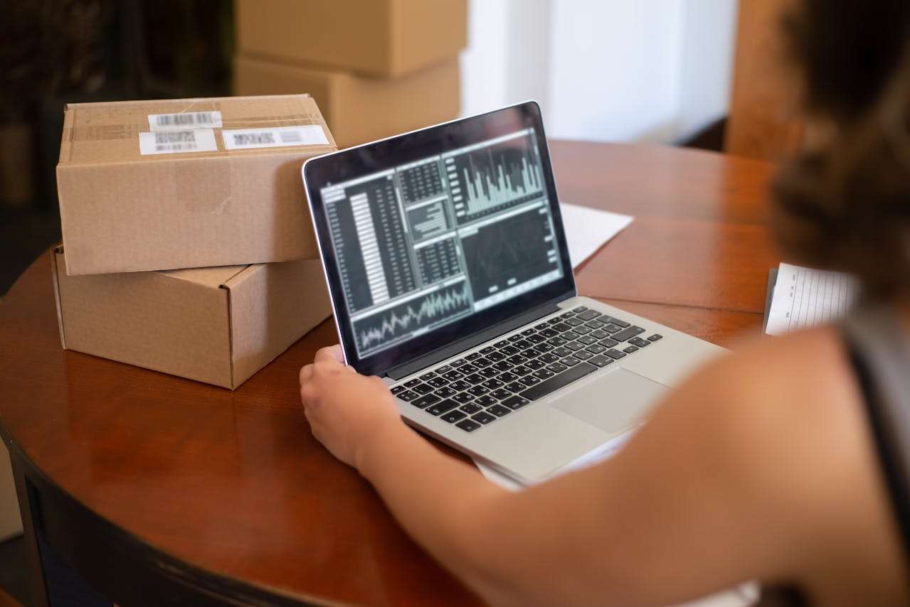 a lady working on a laptop looking at market orders