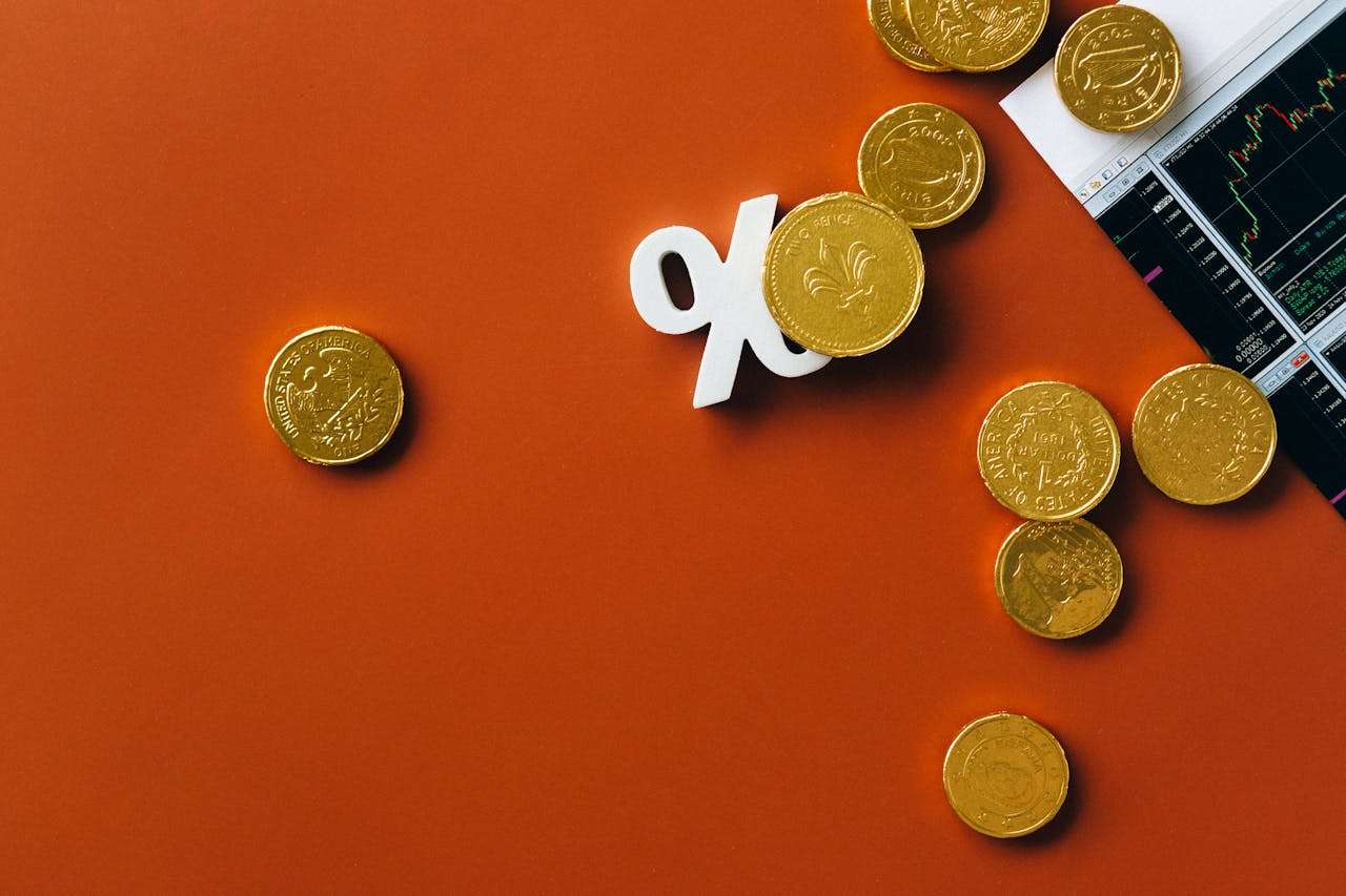 coins over a percentage sign and an investment graph