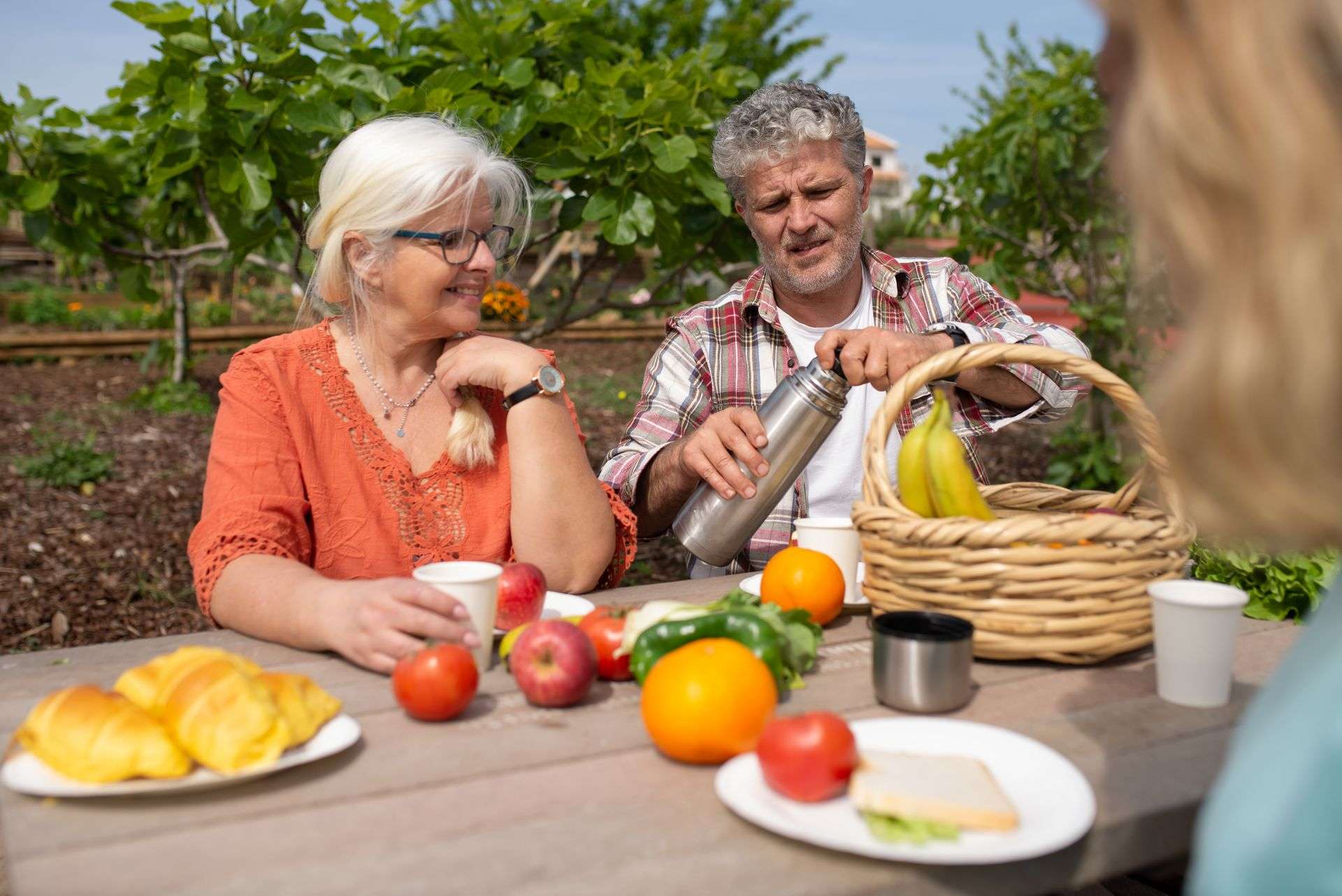 outside picnic with retirees sitting around on a bench