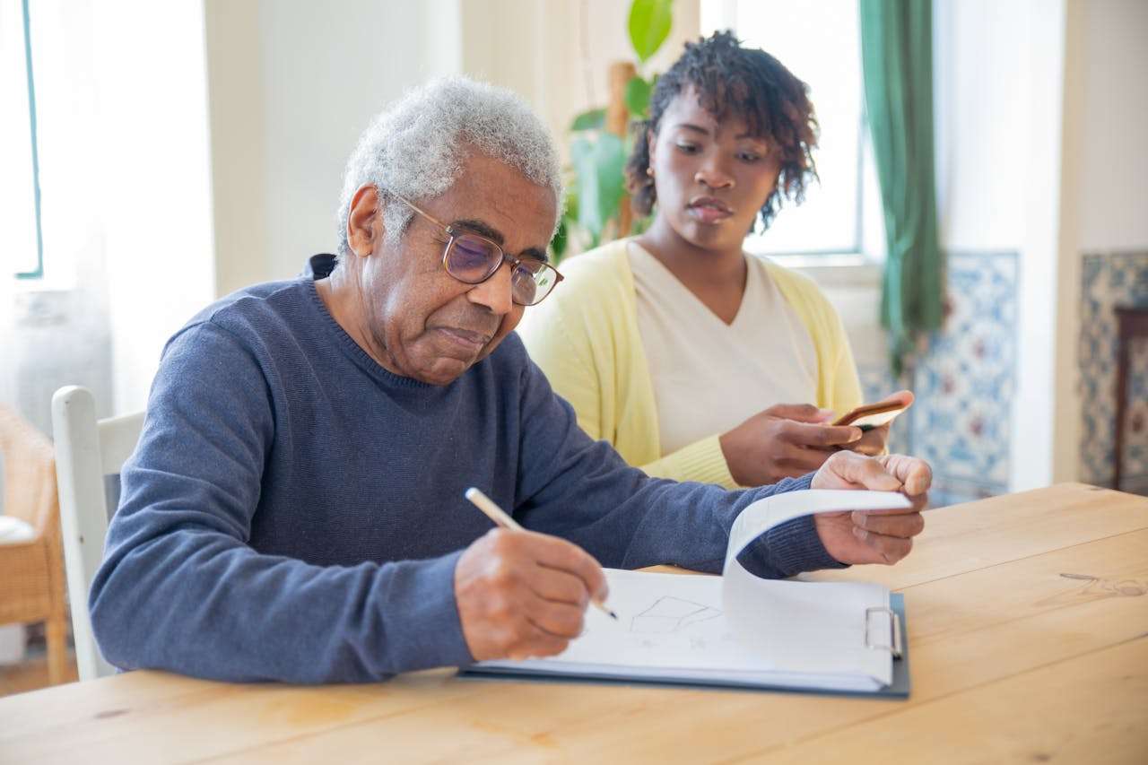 a man sitting signing some papers.