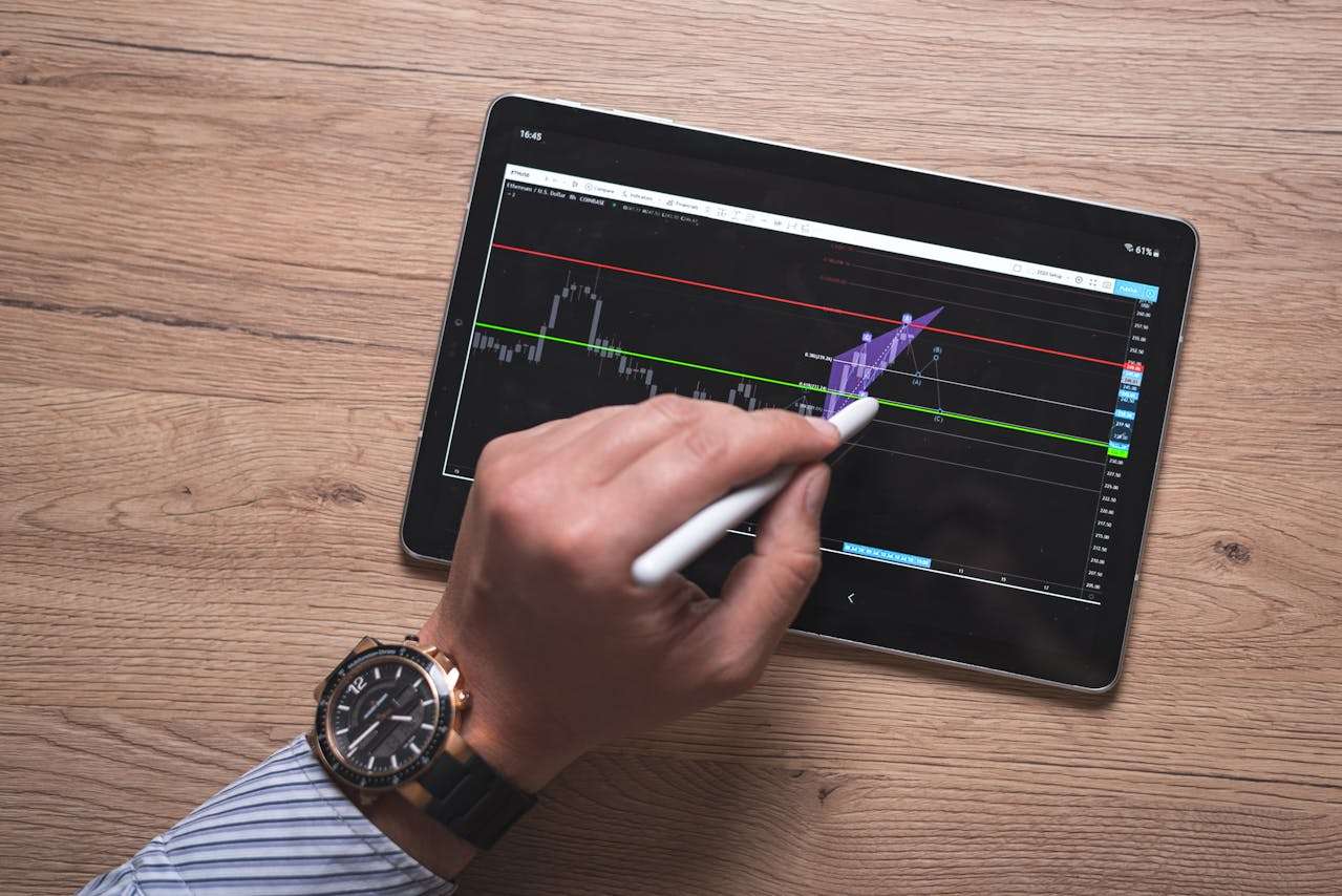 a person using a tablet that shows an investment graph