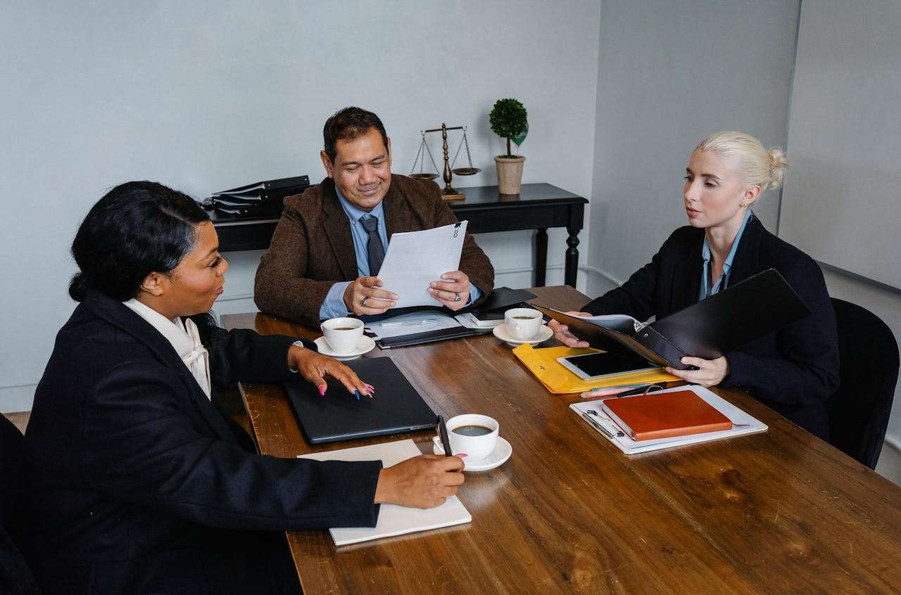 three people in a room discussing documentation