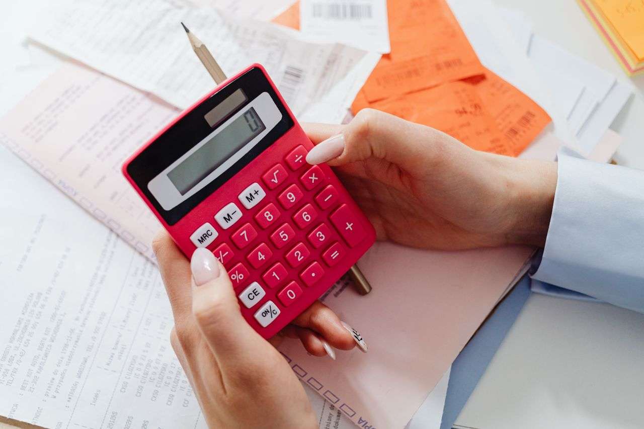 A Person Using A Red Calculator