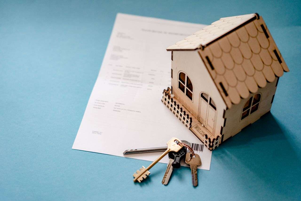 a model house with some keys ontop of documentation